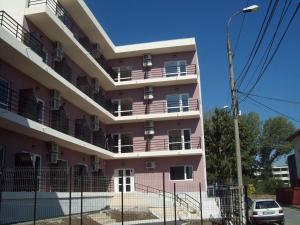 un edificio rosa con balcones en un lateral en Raul, en Eforie Sud