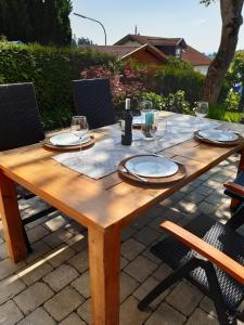 a wooden table with plates and wine glasses on it at Stilvolles Apartment "Romantic" in Neukirchen vorm Wald