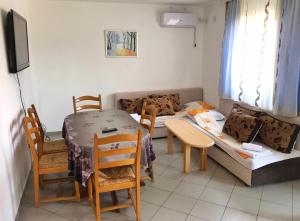 Habitación con 2 camas, mesa y sillas en Apartmani Novak - Srebrno jezero, en Veliko Gradiste