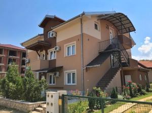 una casa con una escalera de caracol en el lateral. en Apartmani Novak - Srebrno jezero, en Veliko Gradiste