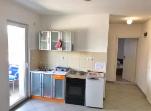 a kitchen with a sink and a stove top oven at Apartmani Novak - Srebrno jezero in Veliko Gradište