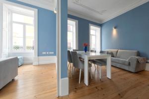 une salle à manger avec des murs bleus, une table et des chaises dans l'établissement Aveiro History Apartments, à Aveiro