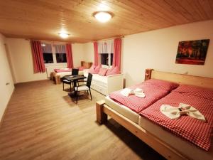 a bedroom with two beds and a table and chairs at Penzion U Lípy in Ostrov