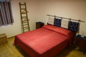 Schlafzimmer mit einem roten Bett und einer Leiter in der Unterkunft Le Case del Vento - APPARTAMENTO MAESTRALE in Torre Canne