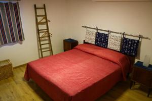 Un dormitorio con una cama roja y una escalera en Le Case del Vento - APPARTAMENTO MAESTRALE, en Torre Canne
