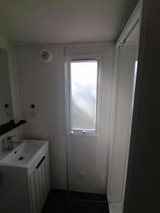 a bathroom with a window and a sink and a shower at Camping de masevaux in Masevaux