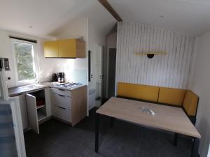 una pequeña cocina con un banco y una mesa en Camping de masevaux, en Masevaux