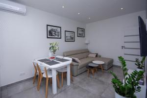 sala de estar con sofá, mesa y sillas en Apartamenty AP 11 en Częstochowa