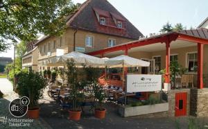 um restaurante com mesas e guarda-sóis em frente a um edifício em Villa Mittermeier, Hotellerie & Restaurant em Rothenburg ob der Tauber