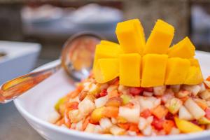 a plate of food with a spoon and a salad at Hotel Vilage Inn All Inclusive Poços de Caldas By Nacional Inn in Poços de Caldas