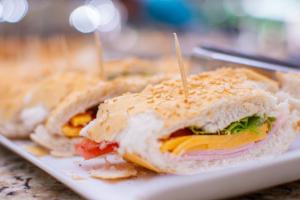 a sandwich is cut in half on a plate at Hotel Vilage Inn All Inclusive Poços de Caldas By Nacional Inn in Poços de Caldas