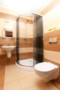 La salle de bains est pourvue d'une douche, de toilettes et d'un lavabo. dans l'établissement Ośrodek Vega, à Pobierowo