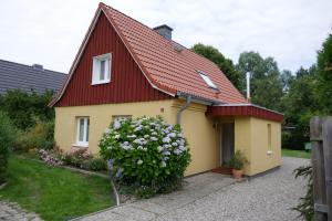 a small yellow house with a red roof at Öko-Ferienwohnung-Kiel Silbermöwe in Kiel