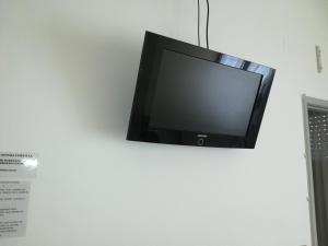 uma televisão de ecrã plano pendurada numa parede em Hotel Pigalle em Rimini
