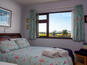 a bedroom with a bed and a window with towels on it at A fourteen in Kilkeel