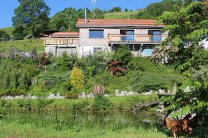 een huis bovenop een heuvel naast een rivier bij chalet bel horizon La Montagne Des Lamas in La Bresse