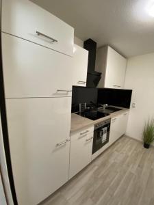 a kitchen with white cabinets and a stove at Bella Luna in Überlingen +4 photos
