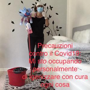 Una donna con una maschera che tiene una scopa in camera da letto di La Casetta a Pescantina