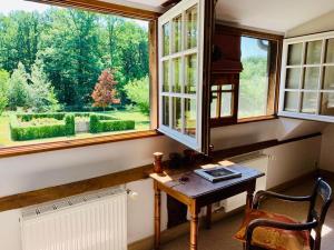a room with a desk and a large window at Les Vieux Guays in Cerdon