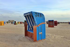 ドルヌムにあるFerienwohnungen "Zur Friesen Freude"の砂の上に座る青い大きな椅子