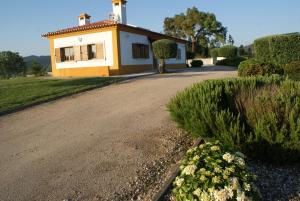 a small yellow and white house on a road at Casa da Eira em Dornes - Casa de campo familiar com piscina in Dornes