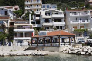 a building on the water in front of buildings at Apartmani California in Podgora