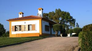a small yellow and white house with a driveway at Casa da Eira em Dornes - Casa de campo familiar com piscina in Dornes
