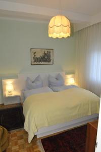 1 dormitorio con 1 cama blanca grande con lámpara de araña en Villa Siebenruh, en Obervellach