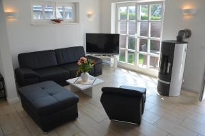 ein Wohnzimmer mit einem Sofa und einem TV in der Unterkunft Ferienhauser Lensterstrand in Lenste