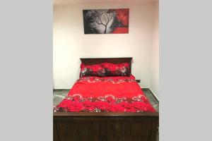 a bedroom with a red bed with flowers on it at Bright, stylish Studio flat with Sky Sports in Earley