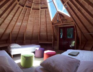 um quarto com 2 camas num chalé de madeira em Tipis Du Petit Buisson em Saint-Antonin-de-Lacalm