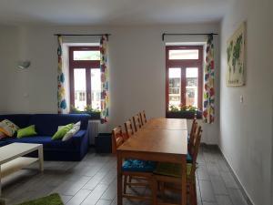 a living room with a table and a blue couch at Thirsty River Rooms in Bovec