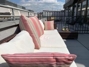- deux canapés blancs installés au-dessus d'un balcon dans l'établissement VULTOR Apartments, à Wrocław