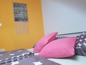 a bed with pink and purple pillows on it at Thirsty River Rooms in Bovec