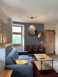 uma sala de estar com um sofá azul e uma mesa em Tour Ramus- appartements em Albertville