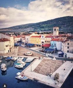 a town with boats in the water and buildings at Apartment Brđanović in Cres