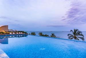 a large swimming pool with a view of the ocean at Hotel Irotama XXI in Santa Marta