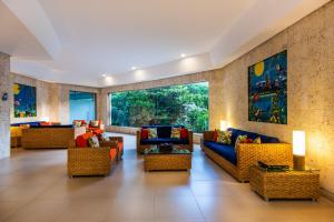 a lobby with couches and chairs and a large window at Hotel Irotama XXI in Santa Marta
