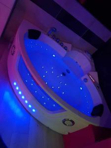 een blauw bad met verlichting in een kamer bij desirs-spa in Saint-Amarin