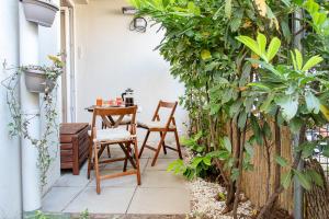 a patio with a table and chairs and trees at Green Oasis apartment Vienna in Vienna