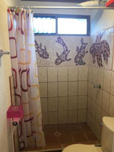 a bathroom with a shower with a giraffe shower curtain at Owl House in Piedades