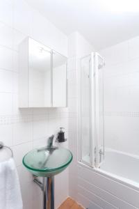 a white bathroom with a sink and a shower at Absolute Stays at The Qube -Utilita-City Center-The Rep-ICC-NIA-Edgbaston Cricket-Free WIFI- Contractors-Sealife-BrindleyPlace in Birmingham