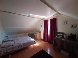 ein Schlafzimmer mit einem Bett und einem roten Vorhang in der Unterkunft Bienvenue chez les GIBBS! in Sury-en-Vaux