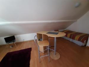 ein kleines Zimmer mit einem Tisch und einem Bett in der Unterkunft Bienvenue chez les GIBBS! in Sury-en-Vaux