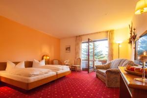 ein Hotelzimmer mit einem Bett und einem Sofa in der Unterkunft Hotel Thüringer Hof in Floh