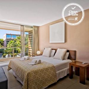 - une chambre avec un lit et une grande fenêtre dans l'établissement Herdade dos Salgados Beach apartment, à Albufeira
