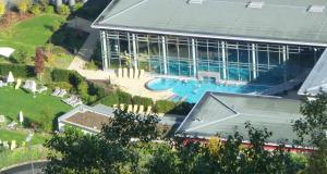 an aerial view of a large building with a swimming pool at Bertricher Hof Hotel Garni in Bad Bertrich