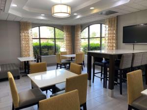 a waiting room with tables and chairs and a flat screen tv at Best Western Executive Inn & Suites in Columbia