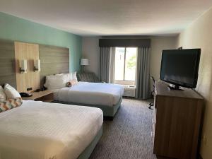 a hotel room with two beds and a flat screen tv at Best Western Executive Inn & Suites in Columbia