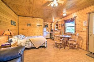 a bedroom with a bed and a table and chairs at Rustic Davis Cabin Less Than half Mile to Turner Falls! in Davis